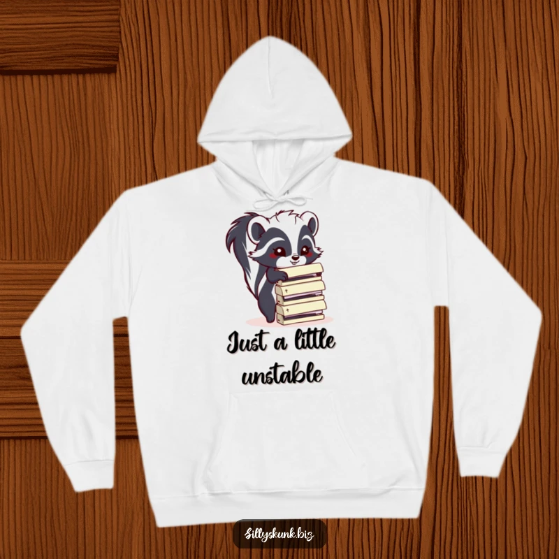 Funny skunk wearing a hoodie, attempting to stack office staplers, ideal for a cozy and funny gift.